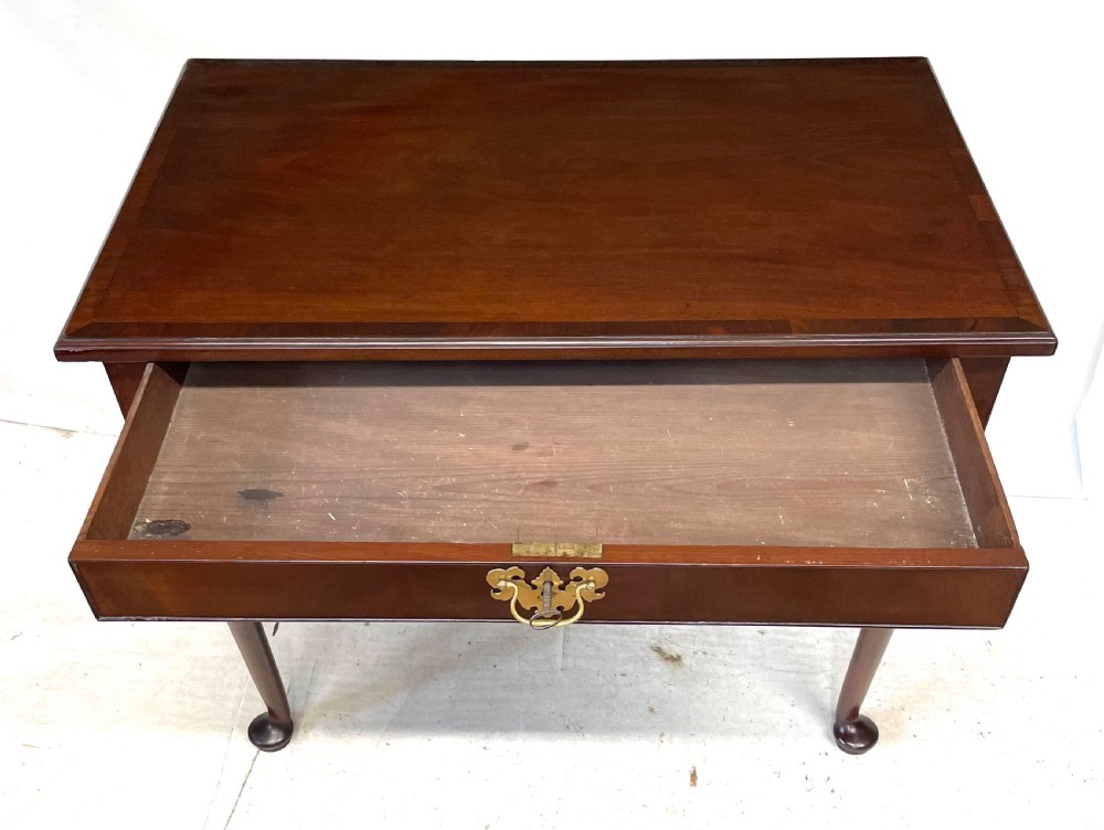 An antique Georgian mahogany side table featuring a rectangular top with a moulded rim, a single drawer with brass hardware, and slender cabriole legs ending in pad feet. View XV