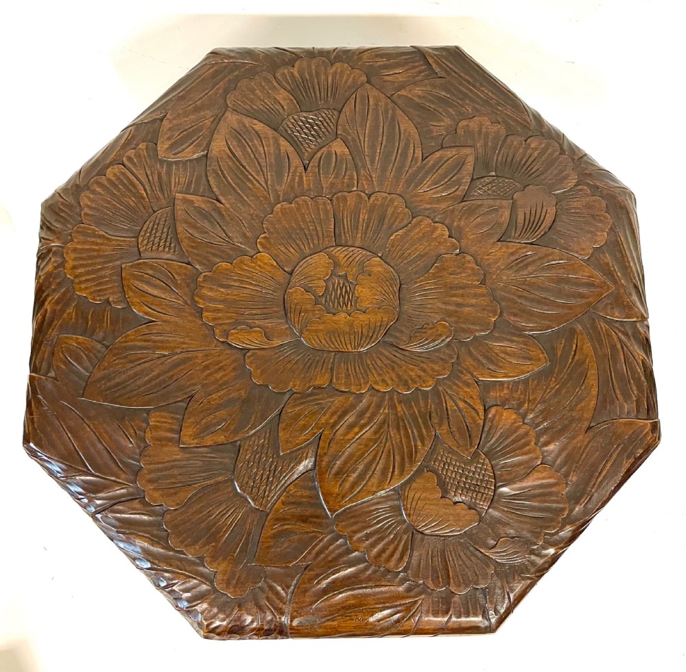 A dark wood side table with an octagonal top deeply carved with floral details, supported by a central tree trunk and a carved standing bear figure. View XX