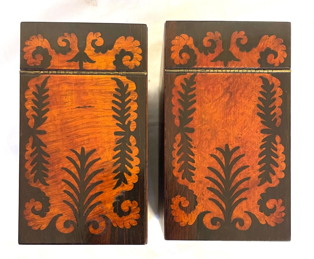 A George IV sarcophagus-shaped wooden tea caddy featuring amboyna veneers, intricate marquetry foliate inlay, a central escutcheon with key, and stepped lid construction. View XVIII