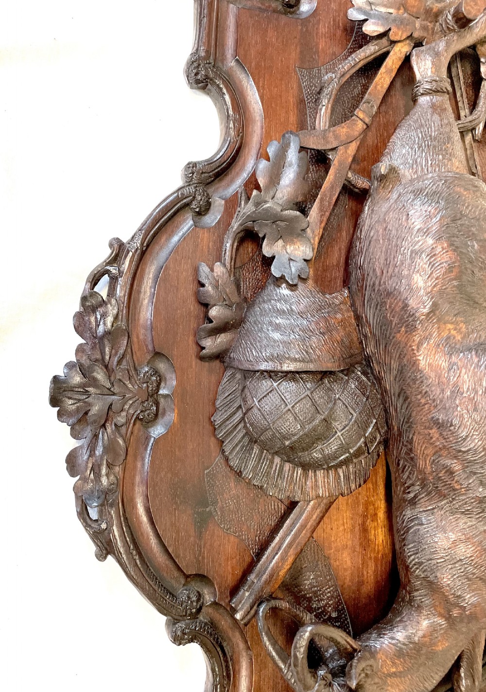 A pair of 19th-century carved dark wood wall plaques depicting hunted game, including a chamois and birds framed by oak foliage and hunting gear. View XIX