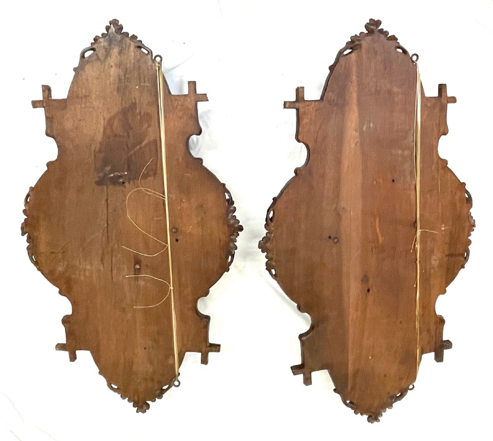 A pair of 19th-century carved dark wood wall plaques depicting hunted game, including a chamois and birds framed by oak foliage and hunting gear. View XXI