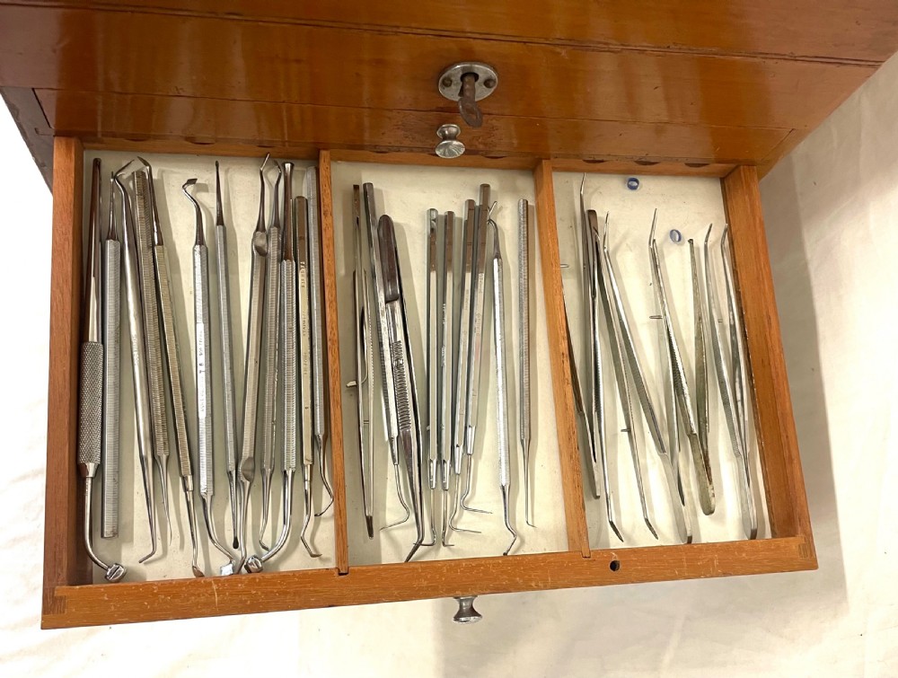 A rectangular wooden portable dental cabinet with six graduated drawers, silver-coloured metal pull knobs, a metal keyhole escutcheon, and a top carrying handle. View XIV