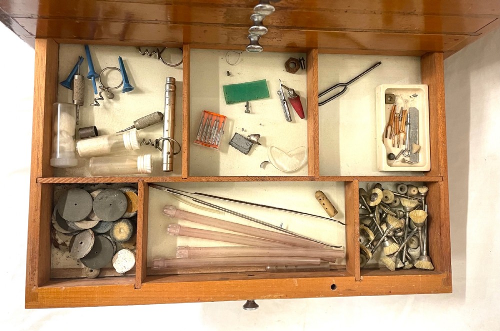 A rectangular wooden portable dental cabinet with six graduated drawers, silver-coloured metal pull knobs, a metal keyhole escutcheon, and a top carrying handle. View XVI