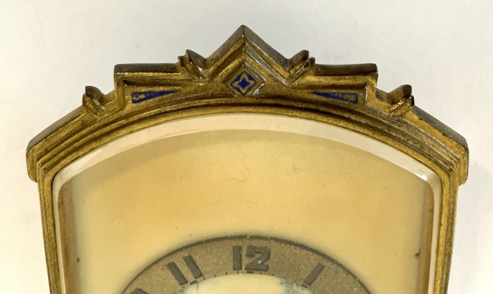 An antique miniature gilt metal easel clock featuring a painted landscape dial surrounded by champleve enamel floral decoration at the base. View IV