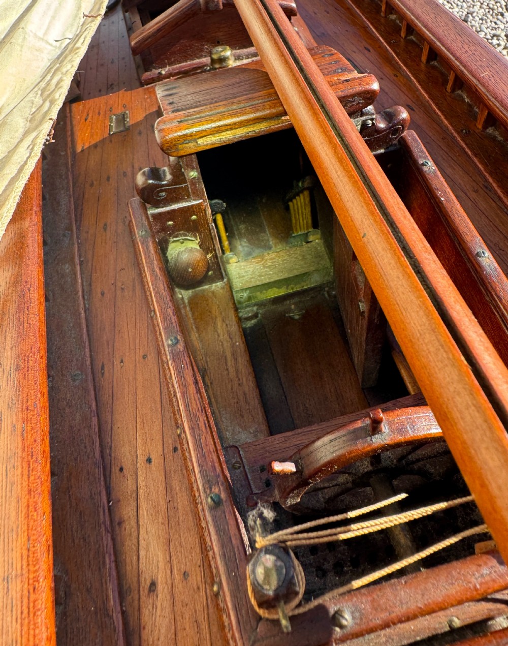 A large Victorian wooden pond yacht with stitched fabric sails, brass deck fittings, and a carved wooden keel, displayed on a wooden stand. View XVIII