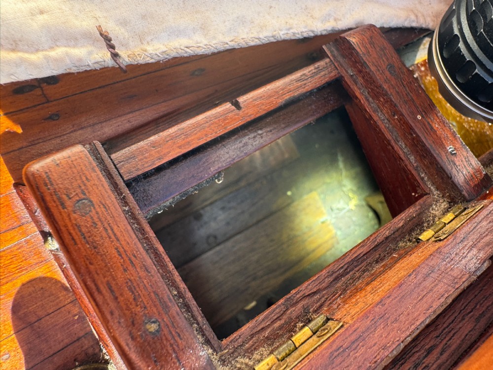 A large Victorian wooden pond yacht with stitched fabric sails, brass deck fittings, and a carved wooden keel, displayed on a wooden stand. View XXI