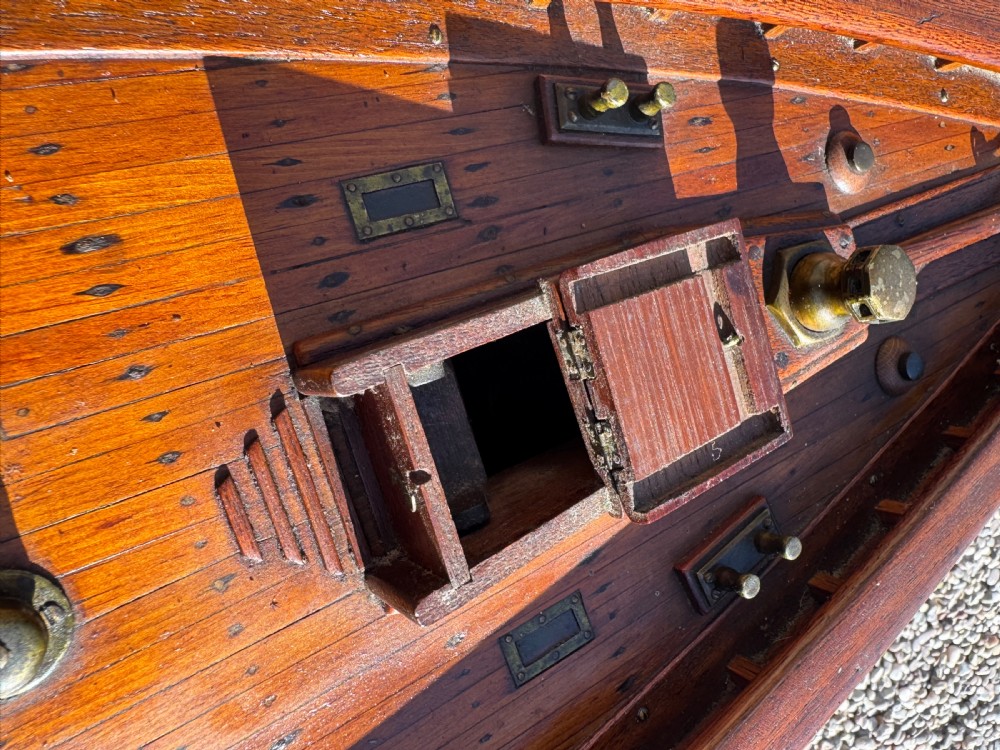 A large Victorian wooden pond yacht with stitched fabric sails, brass deck fittings, and a carved wooden keel, displayed on a wooden stand. View XXII