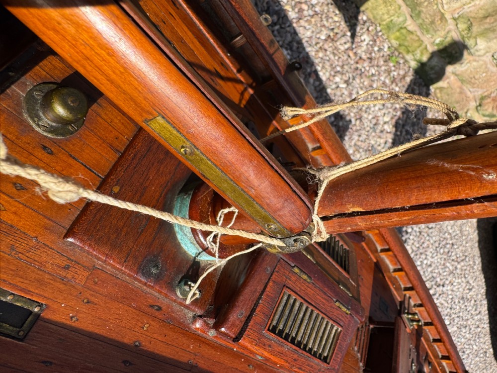 A large Victorian wooden pond yacht with stitched fabric sails, brass deck fittings, and a carved wooden keel, displayed on a wooden stand. View XXIII