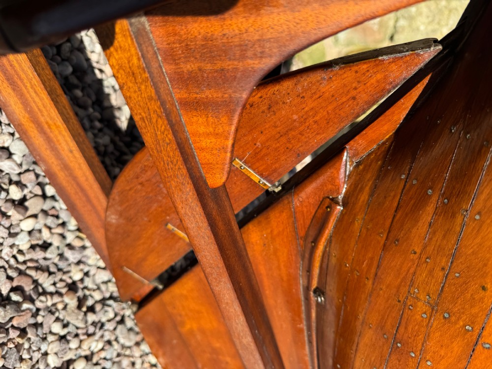 A large Victorian wooden pond yacht with stitched fabric sails, brass deck fittings, and a carved wooden keel, displayed on a wooden stand. View XXVI