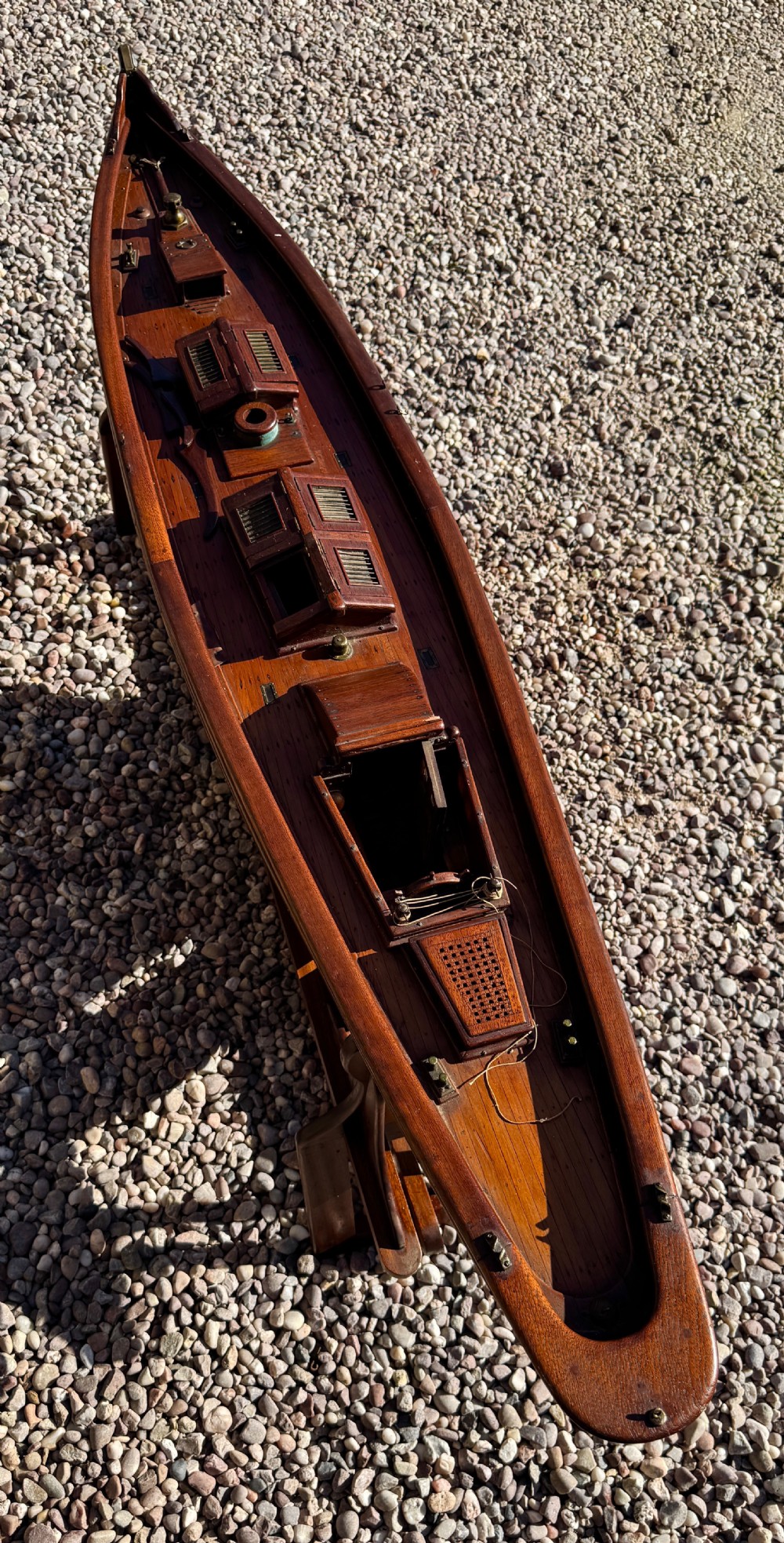 A large Victorian wooden pond yacht with stitched fabric sails, brass deck fittings, and a carved wooden keel, displayed on a wooden stand. View XXIX