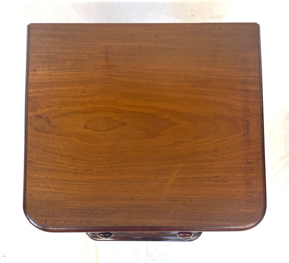 A matching pair of dark mahogany bedside cabinets featuring a top drawer with turned wooden knobs above a recessed arched panel cupboard door set on a plinth base. View IX