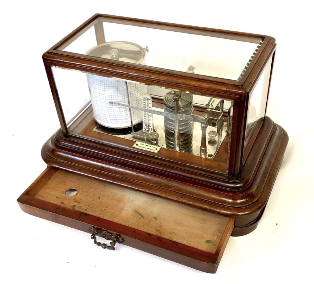 An antique mahogany and glass-cased recording barograph showing internal mechanical brass drums, aneroid pressure cells, and an integrated thermometer above a base drawer. View III