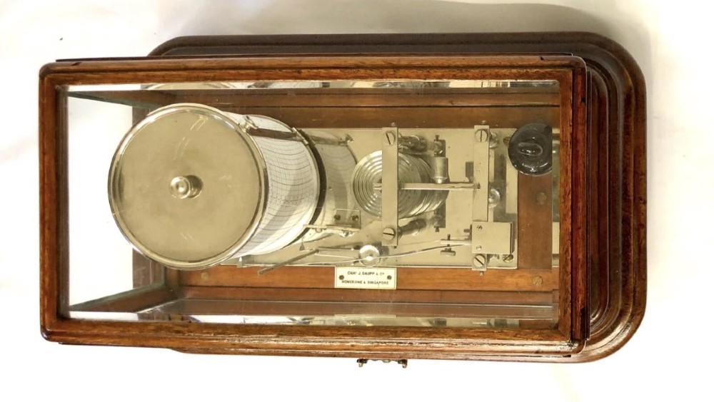 An antique mahogany and glass-cased recording barograph showing internal mechanical brass drums, aneroid pressure cells, and an integrated thermometer above a base drawer. View IV