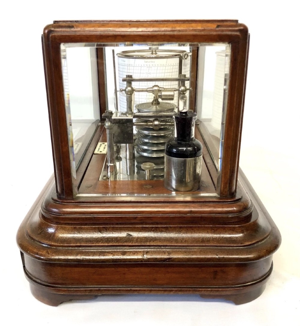 An antique mahogany and glass-cased recording barograph showing internal mechanical brass drums, aneroid pressure cells, and an integrated thermometer above a base drawer. View VI