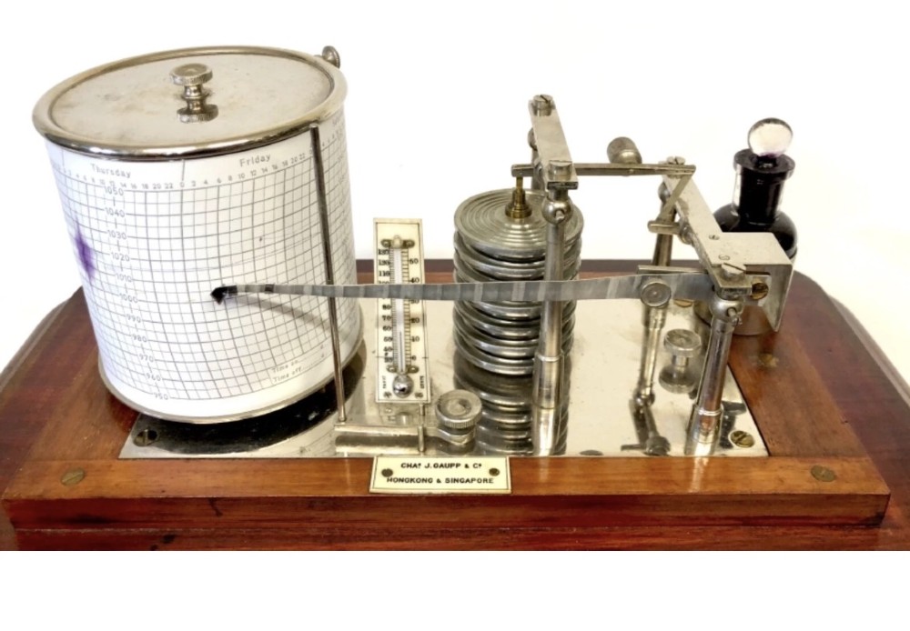 An antique mahogany and glass-cased recording barograph showing internal mechanical brass drums, aneroid pressure cells, and an integrated thermometer above a base drawer. View IX