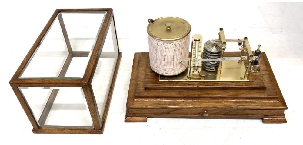 An antique oak cased barograph featuring a brass recording mechanism, internal thermometer, and bevelled glass cover over a base chart drawer. View VIII