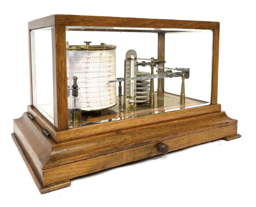 An antique barograph featuring brass recording mechanisms and a paper chart drum enclosed in a glazed oak case with a bottom chart drawer. View III