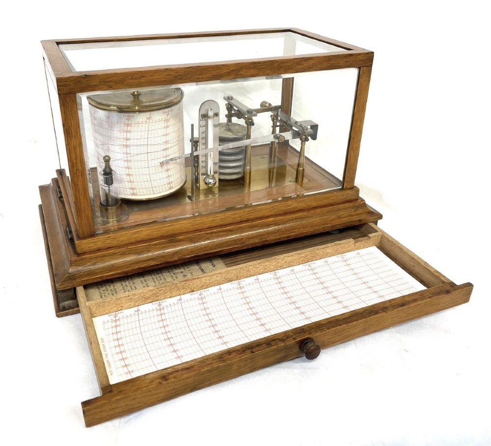 An antique barograph featuring brass recording mechanisms and a paper chart drum enclosed in a glazed oak case with a bottom chart drawer. View V