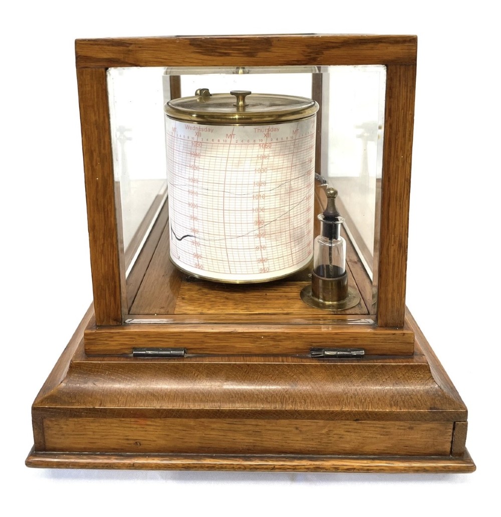 An antique barograph featuring brass recording mechanisms and a paper chart drum enclosed in a glazed oak case with a bottom chart drawer. View VII