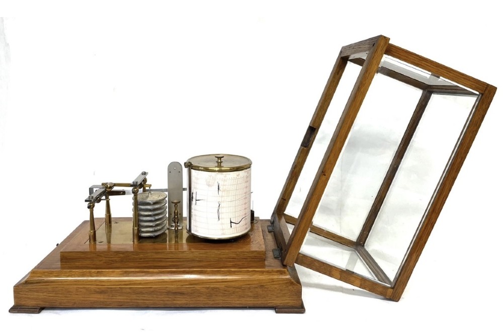 An antique barograph featuring brass recording mechanisms and a paper chart drum enclosed in a glazed oak case with a bottom chart drawer. View XII