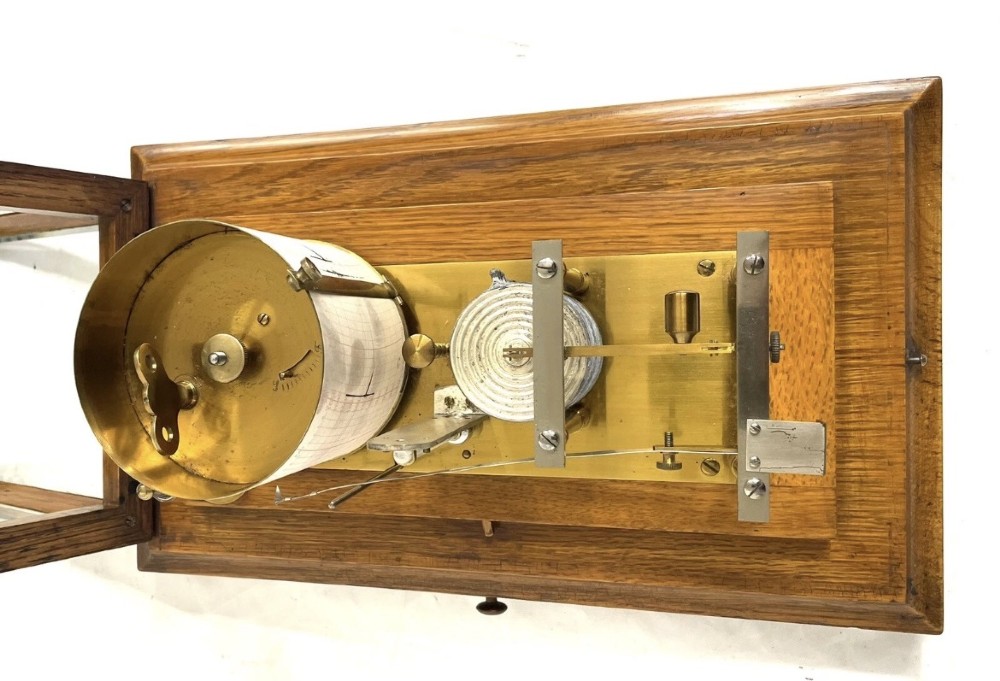 An antique barograph featuring brass recording mechanisms and a paper chart drum enclosed in a glazed oak case with a bottom chart drawer. View XV