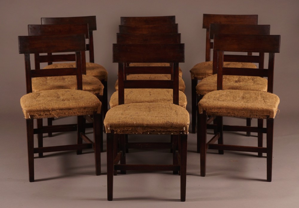 A set of ten George III mahogany dining chairs featuring horizontal bar backrests and hessian-padded drop-in seats.