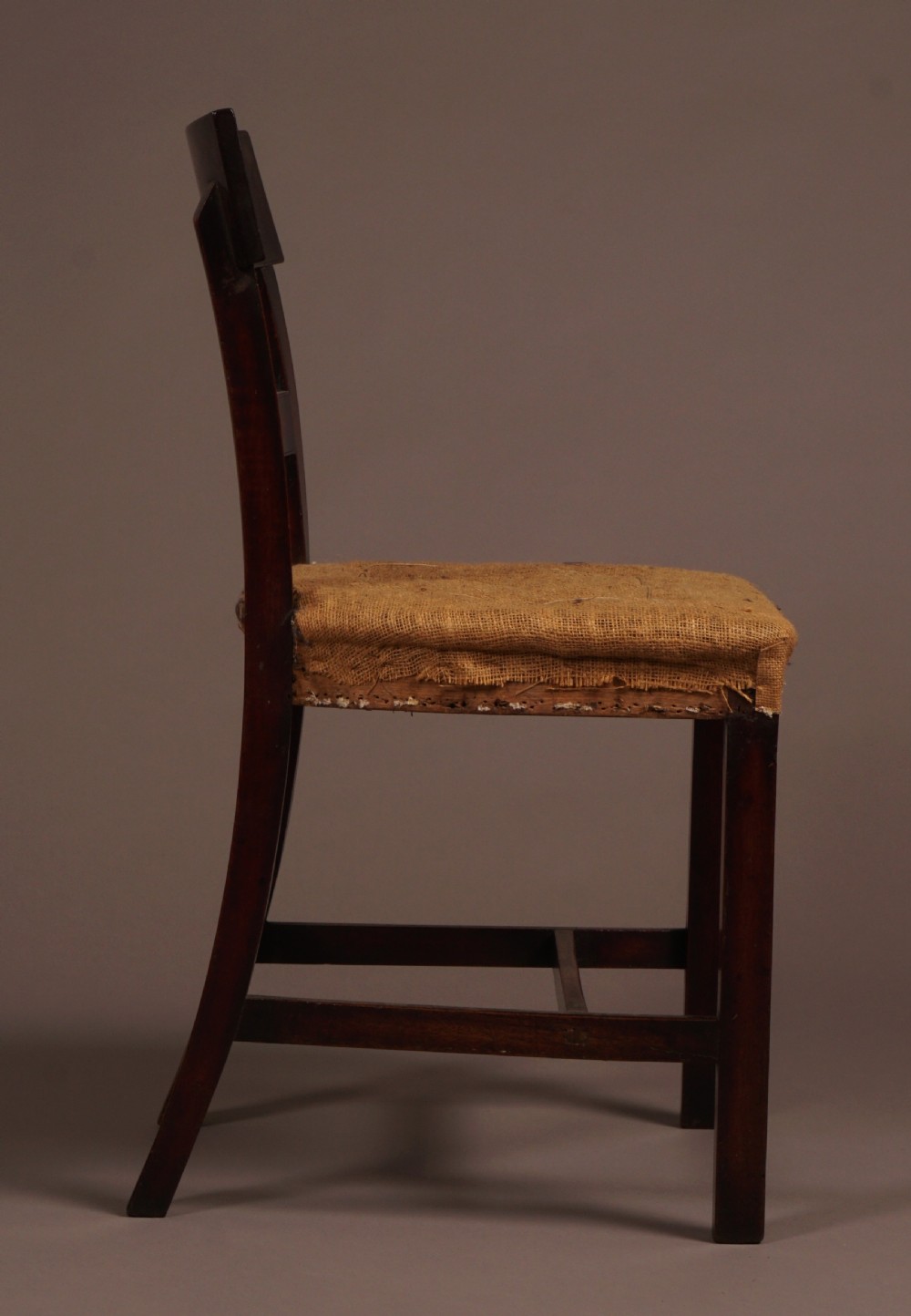 A set of ten George III mahogany dining chairs featuring horizontal bar backrests and hessian-padded drop-in seats. View V