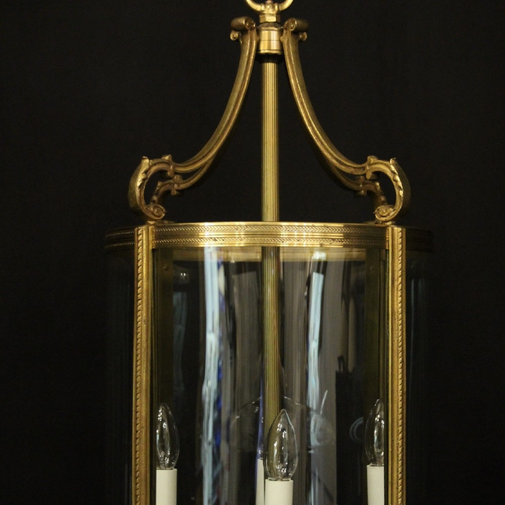 A French gilt bronze cylindrical hall lantern with curved glass panels and internal candle sockets. View II