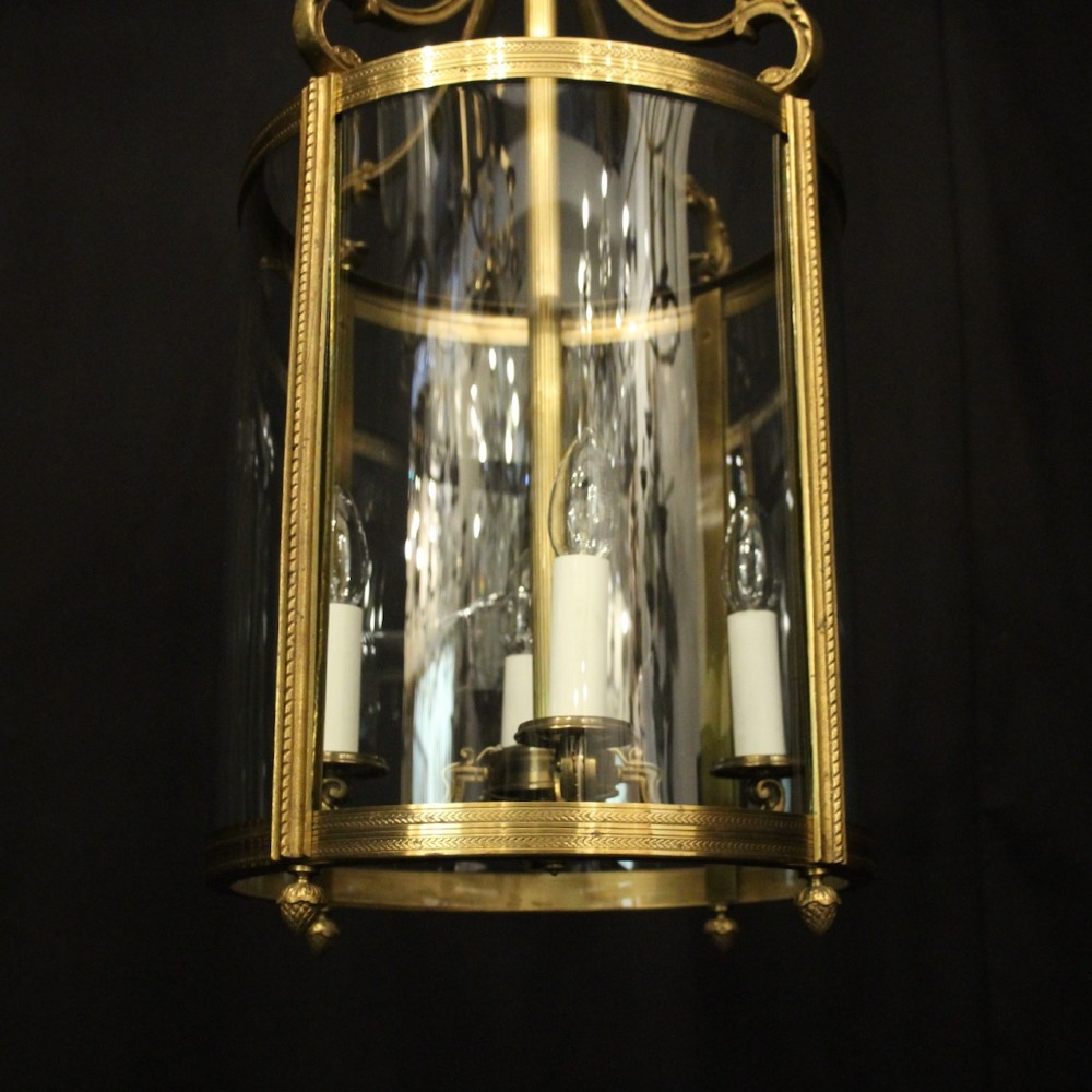 A French gilt bronze cylindrical hall lantern with curved glass panels and internal candle sockets. View V