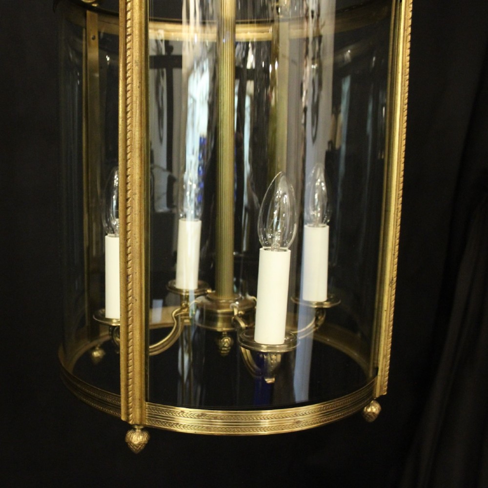 A French gilt bronze cylindrical hall lantern with curved glass panels and internal candle sockets. View VI