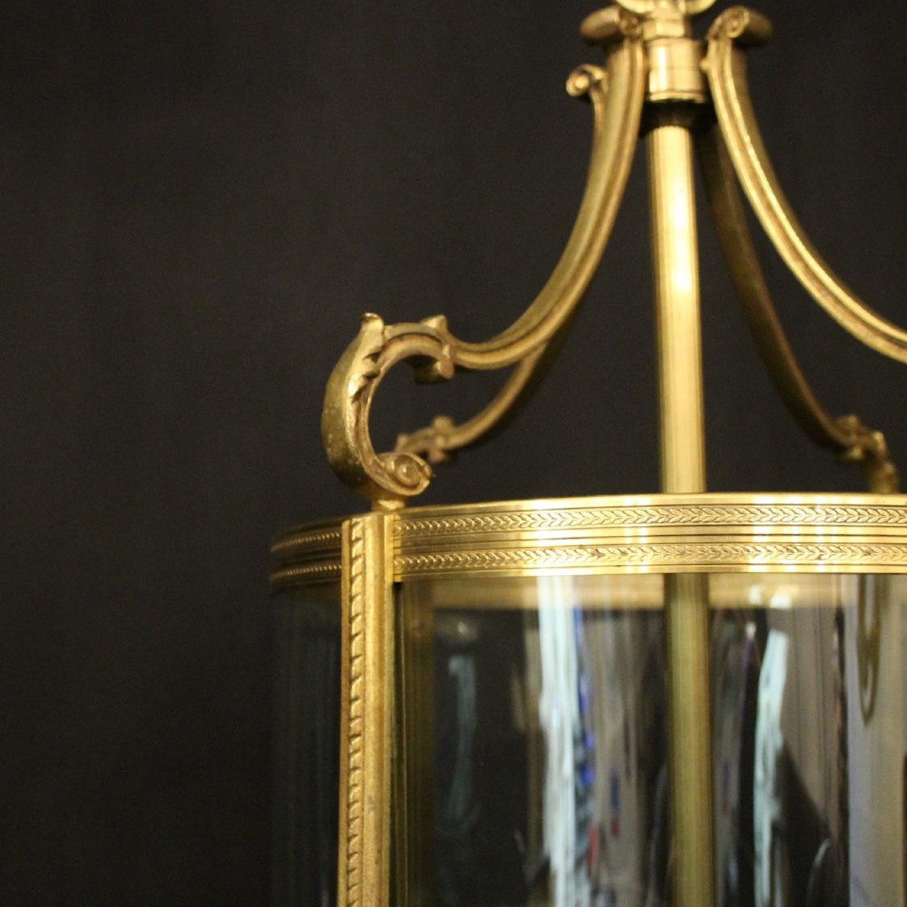 A French gilt bronze cylindrical hall lantern with curved glass panels and internal candle sockets. View VII