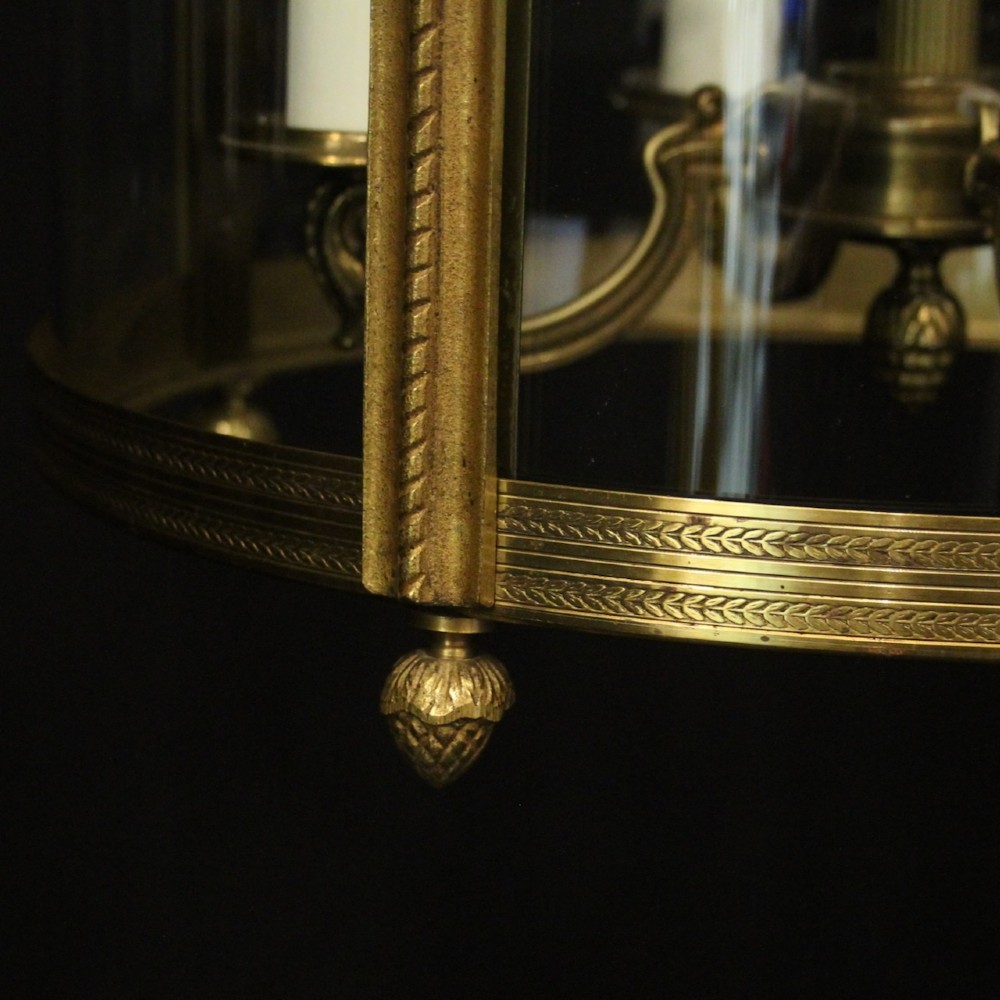 A French gilt bronze cylindrical hall lantern with curved glass panels and internal candle sockets. View IX