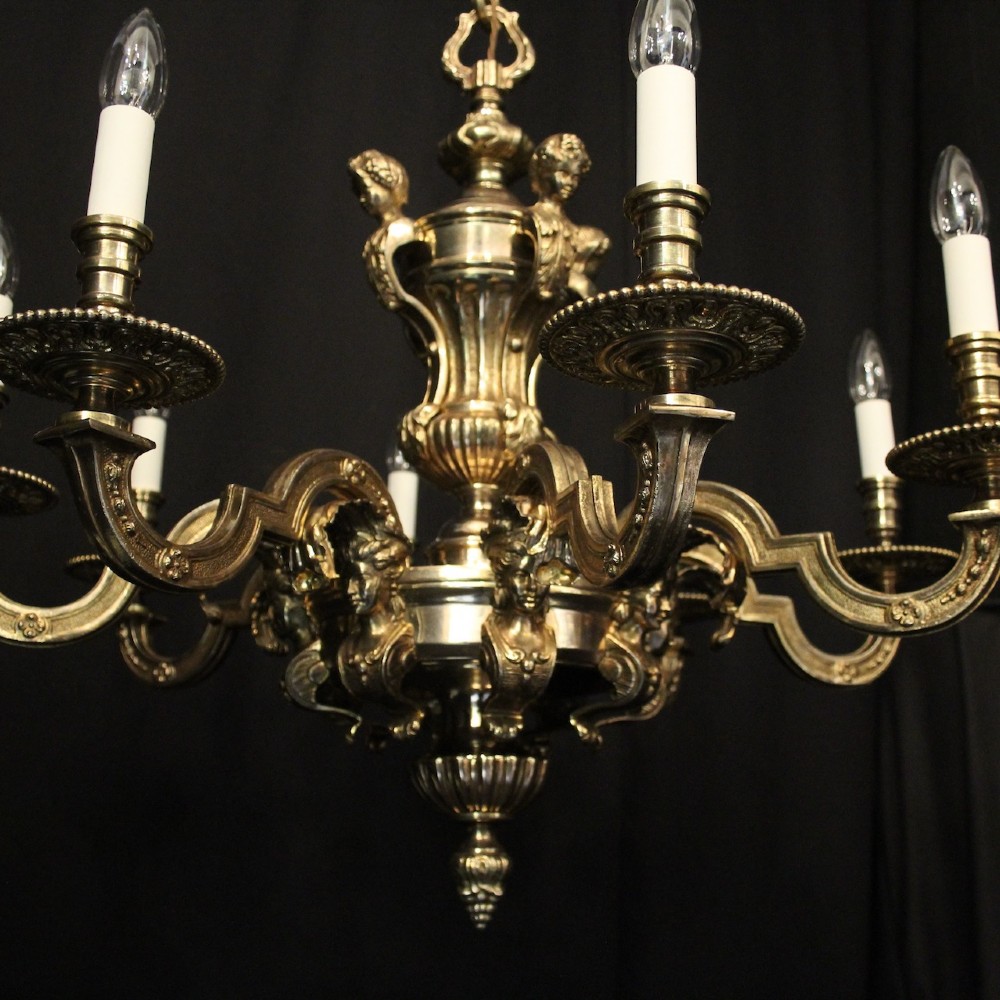 An eight-arm French gilded bronze chandelier with central scrolling stem and candle-effect bulb holders suspended from a chain. View II