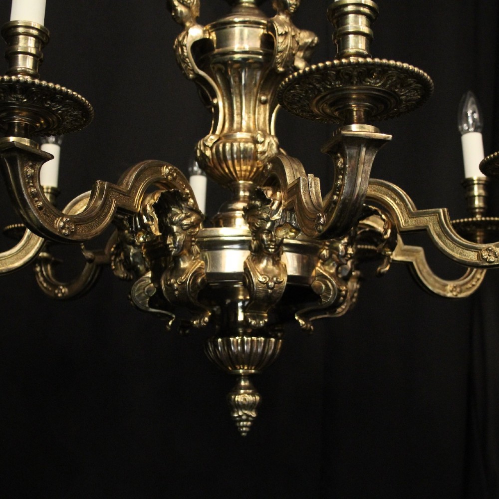 An eight-arm French gilded bronze chandelier with central scrolling stem and candle-effect bulb holders suspended from a chain. View III
