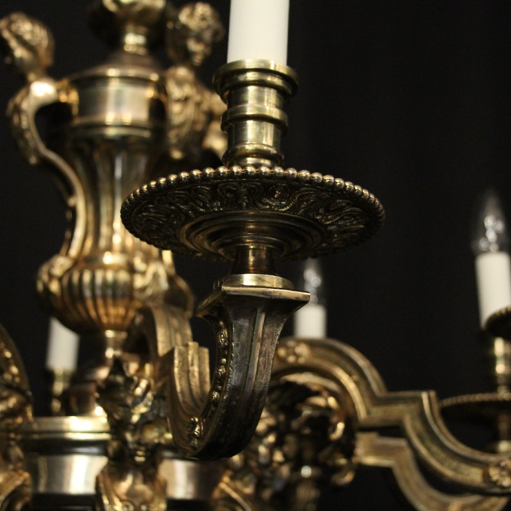 An eight-arm French gilded bronze chandelier with central scrolling stem and candle-effect bulb holders suspended from a chain. View V