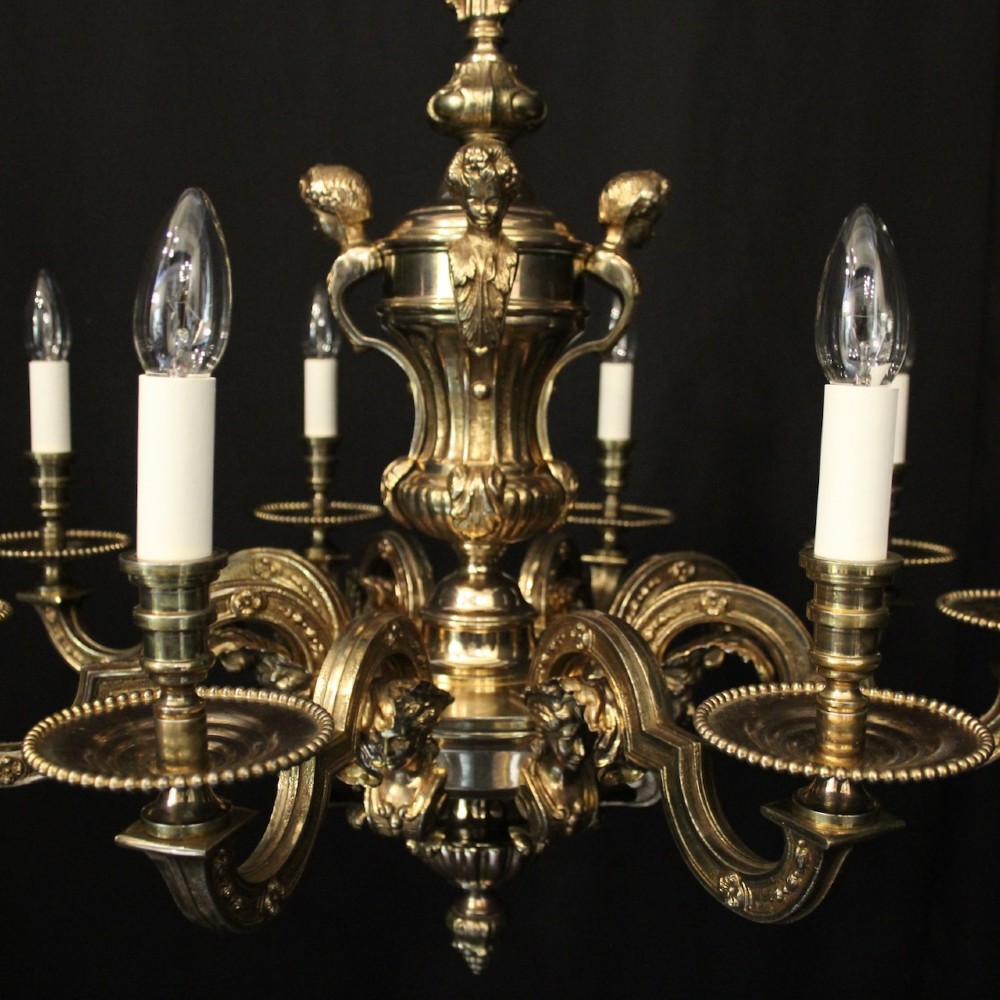 An eight-arm French gilded bronze chandelier with central scrolling stem and candle-effect bulb holders suspended from a chain. View VI