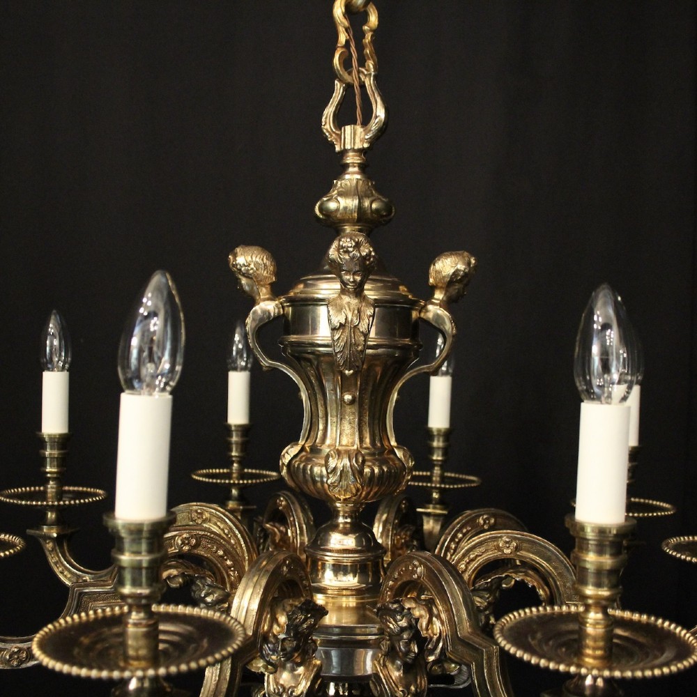 An eight-arm French gilded bronze chandelier with central scrolling stem and candle-effect bulb holders suspended from a chain. View VII