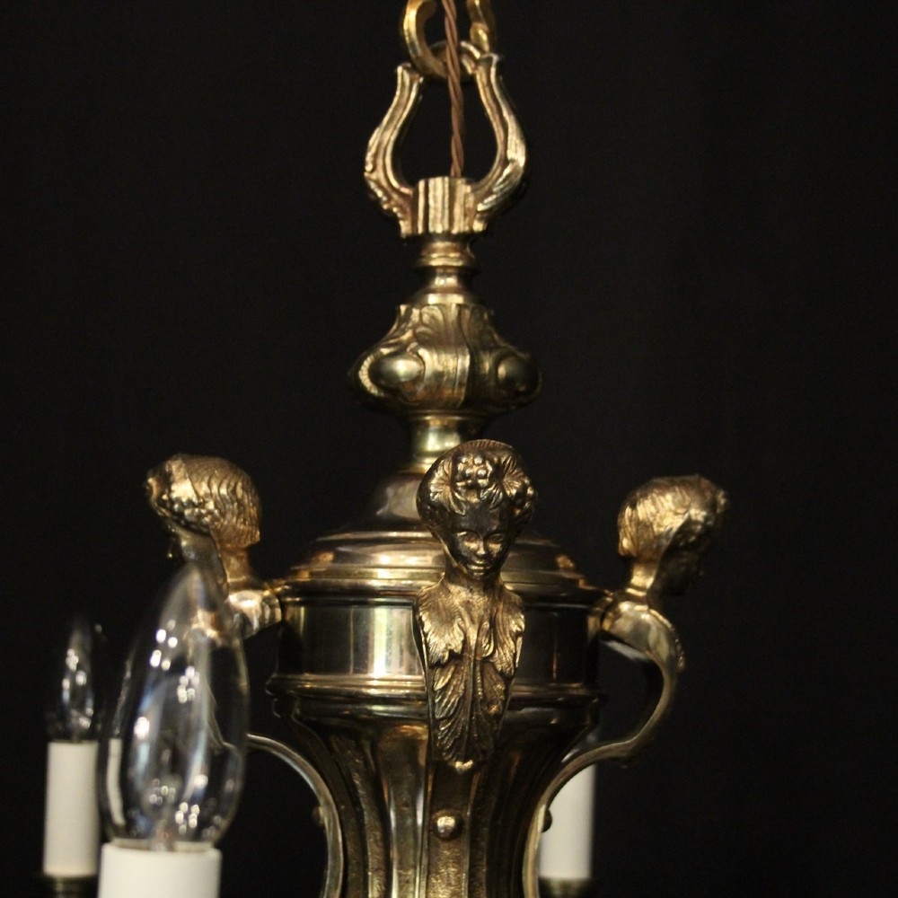 An eight-arm French gilded bronze chandelier with central scrolling stem and candle-effect bulb holders suspended from a chain. View VIII
