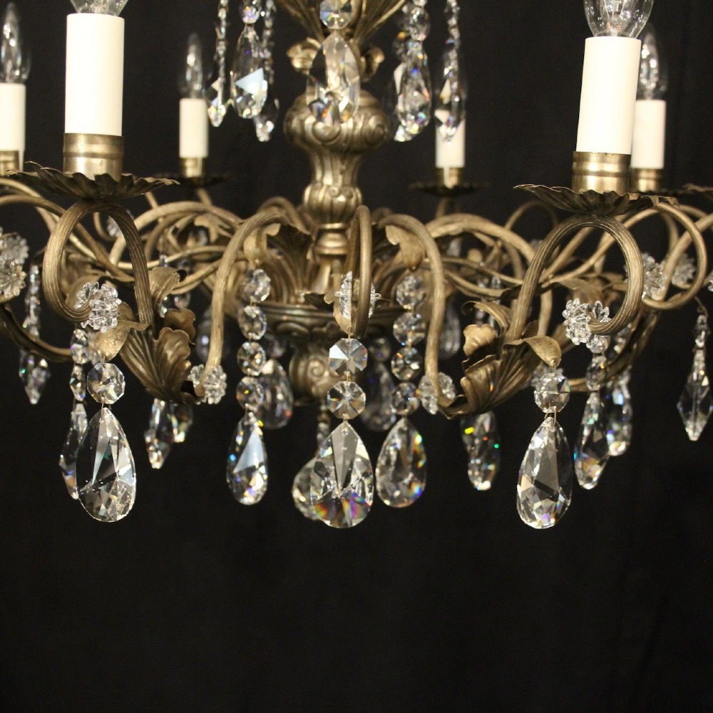 An eight-light Italian chandelier featuring a silvered metal frame decorated with scrolling arms, hanging crystal drops, and glass rosettes. View VI