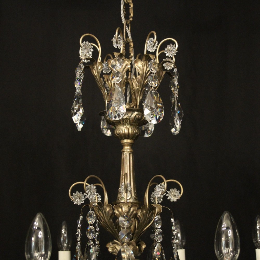 An eight-light Italian chandelier featuring a silvered metal frame decorated with scrolling arms, hanging crystal drops, and glass rosettes. View VIII
