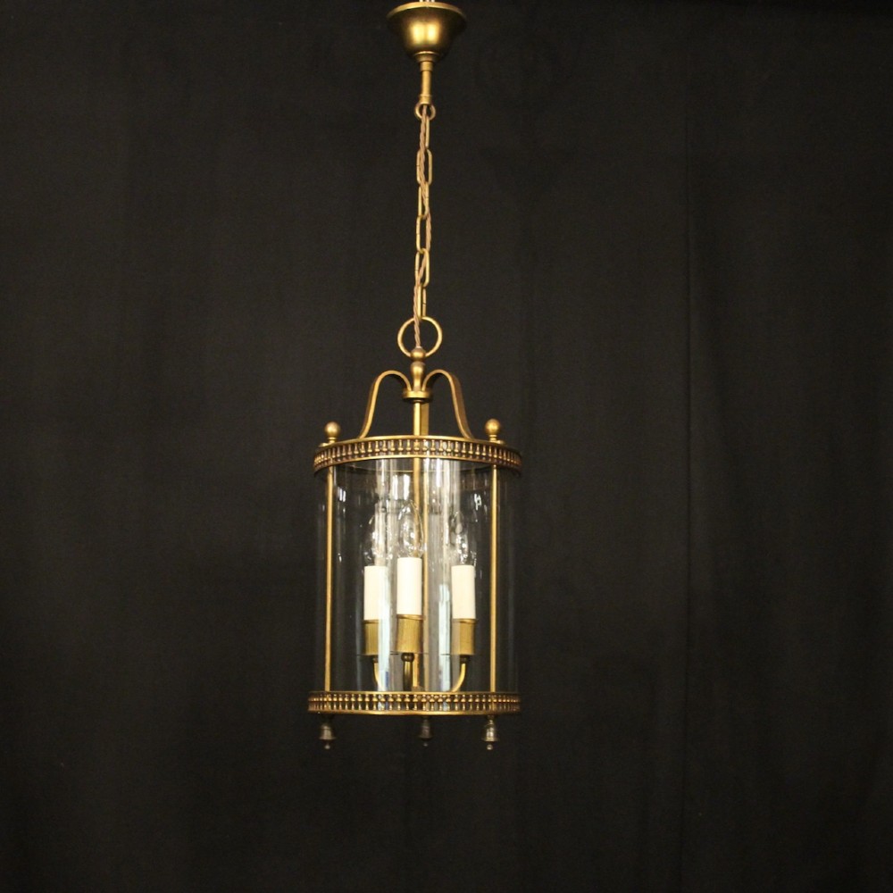 A cylindrical antique French hall lantern crafted from gilded brass with clear glass panels housing a three-light candle cluster. View II
