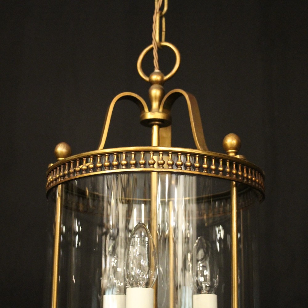 A cylindrical antique French hall lantern crafted from gilded brass with clear glass panels housing a three-light candle cluster. View III