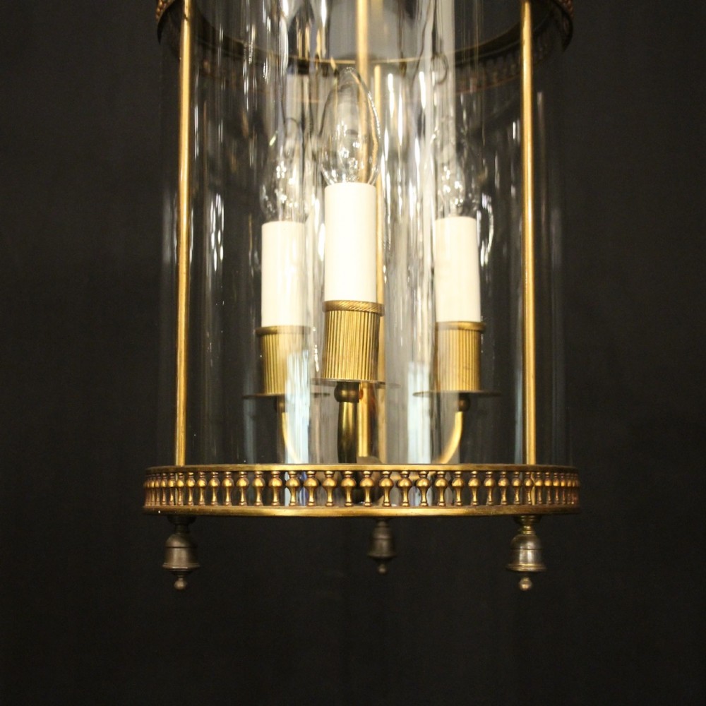 A cylindrical antique French hall lantern crafted from gilded brass with clear glass panels housing a three-light candle cluster. View V