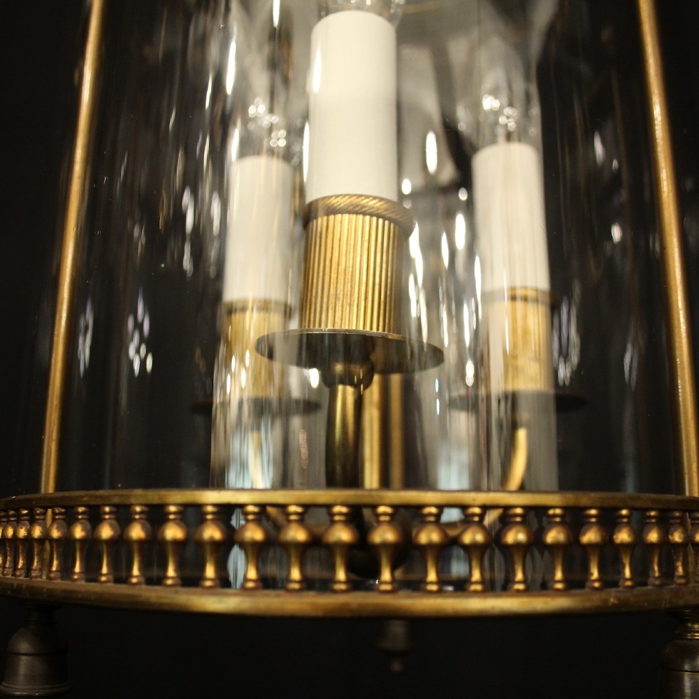 A cylindrical antique French hall lantern crafted from gilded brass with clear glass panels housing a three-light candle cluster. View VII