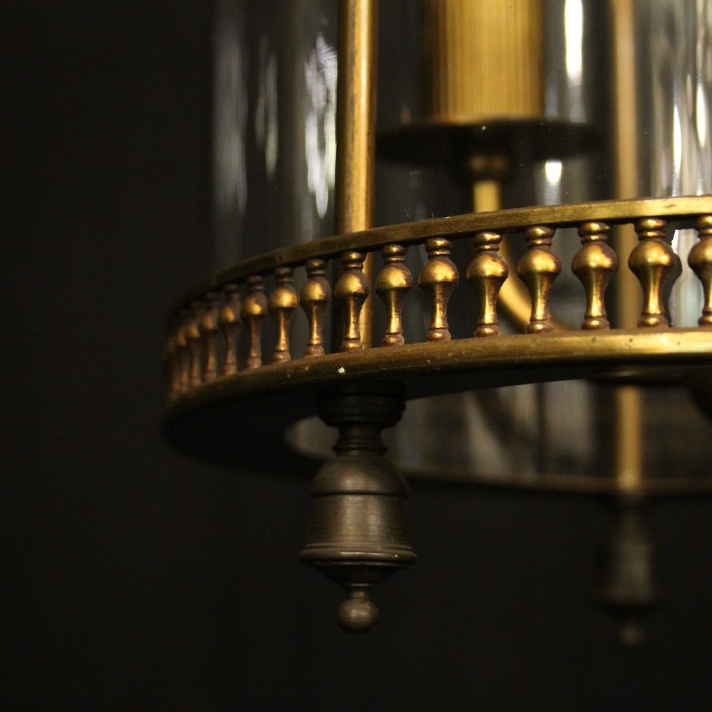 A cylindrical antique French hall lantern crafted from gilded brass with clear glass panels housing a three-light candle cluster. View IX