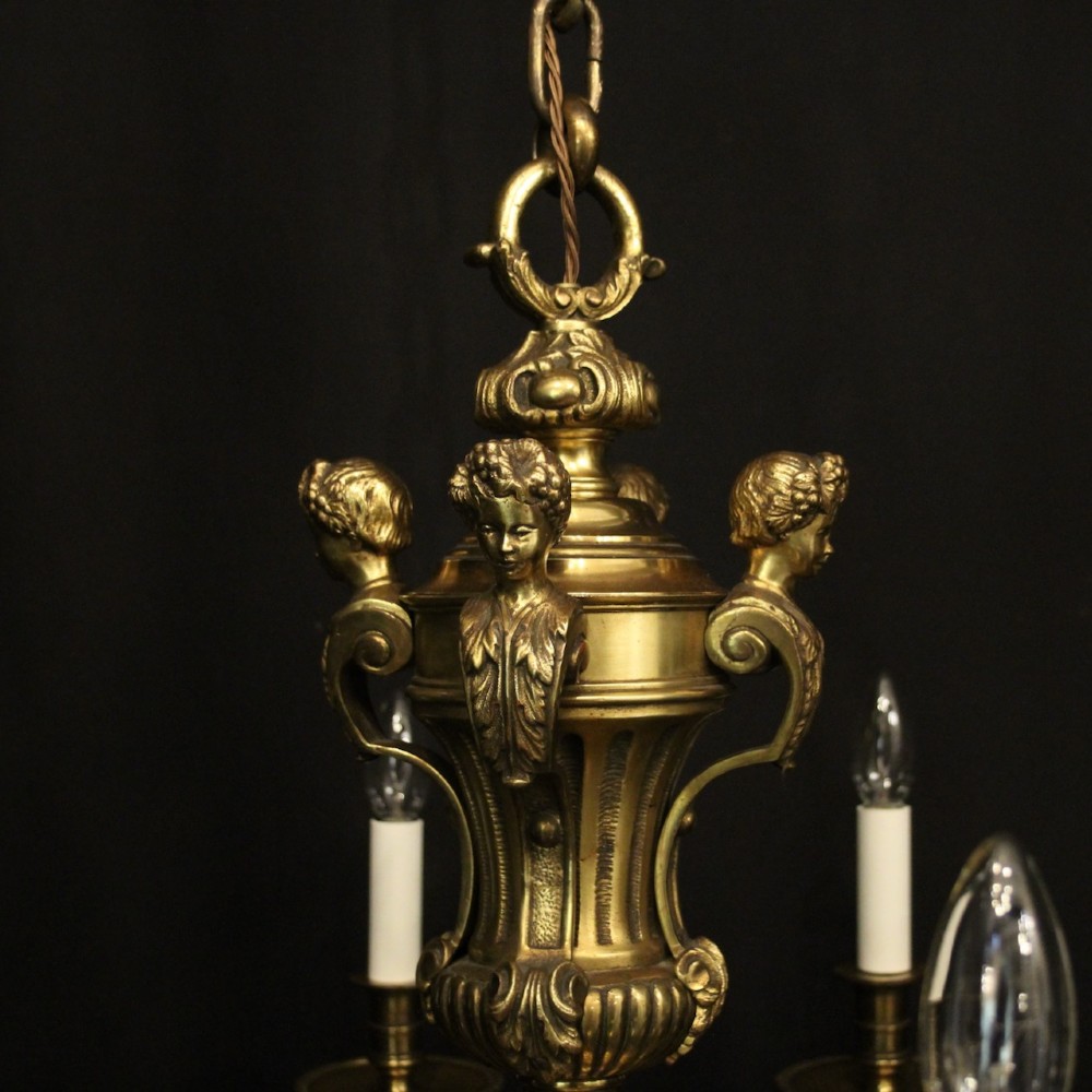 A matching pair of cast bronze eight-light chandeliers featuring ornate scrolled arms, decorative stem castings, and faux candle sleeves. View IX
