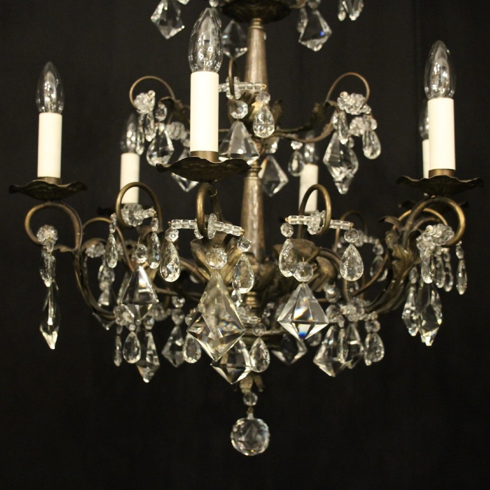 An Italian multi-tiered chandelier featuring a patinated silvered frame adorned with hanging cut-crystal drops, faceted pendants, and six candle-effect light fittings. View II