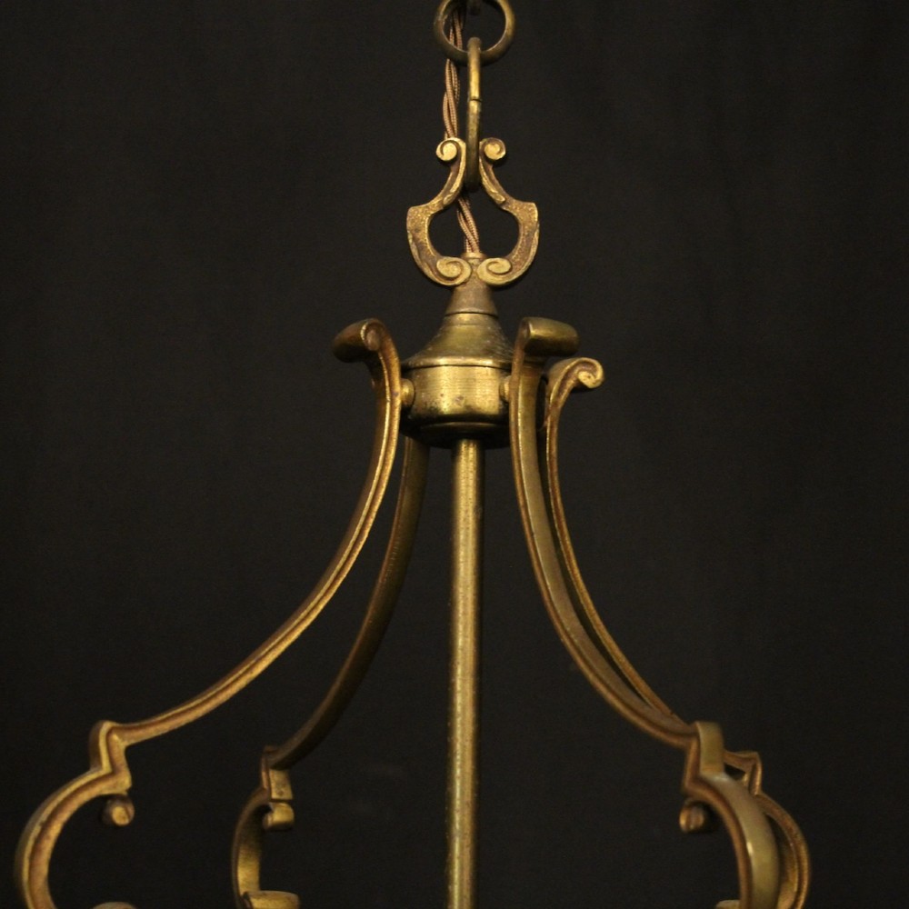 An antique French cylindrical hall lantern featuring a gilded brass frame, curved glass panels, and a three-light interior fitting suspended from a hook. View VII