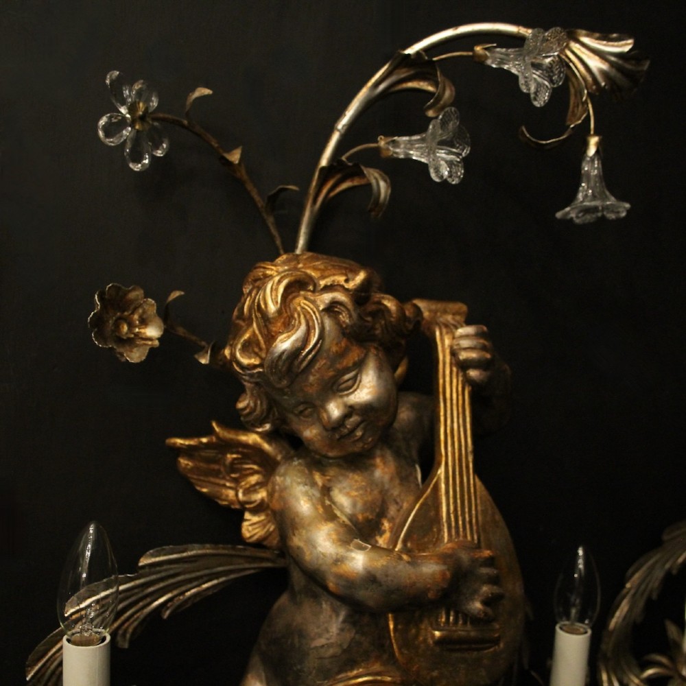 Pair of Italian giltwood wall sconces featuring sculpted cherubs playing musical instruments framed by metal branches with clear glass flowers. View VI