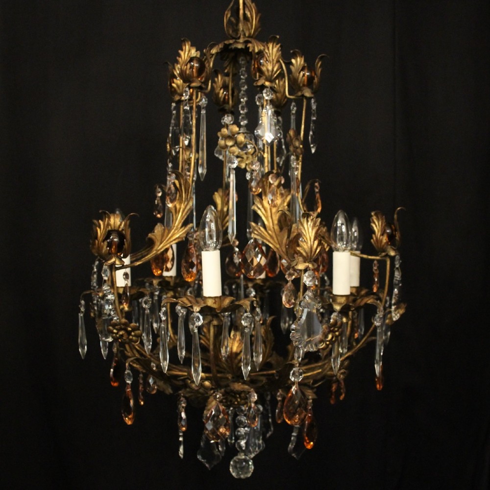 A six-light Florentine chandelier crafted with a gilded leaf metal frame and decorated with suspended clear and amber glass crystal droplets. View II